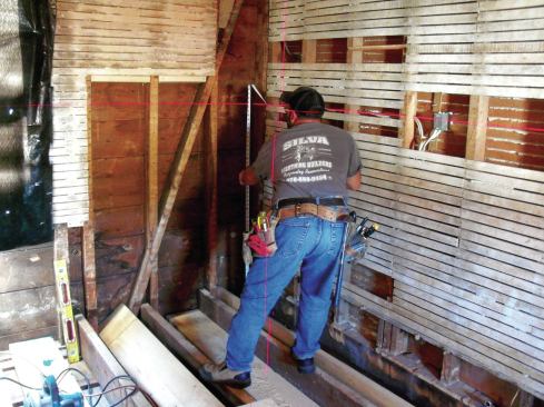 With the high point set, I measured the height from the joist to the laser, then shimmed up the other end of the joist until the measurement matched. At the midpoint of the joist, I measured the gap between the joist and the top plate of the supporting wall below and cut a block to fit. The first joist set the height for the rest of the floor, so it was just a matter of working my way across the floor, bringing each joist up to that level.