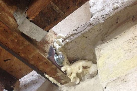 In a few places, project engineer Kathy Dunne specified a steel flitch plate to augment the load-bearing capacity of the existing floor framing. Here, a steel plate is bolted to the end of a wood joist, and bedded into the wall next to it. Says Dunne: “To stay in the wood vocabulary, you would need an 18-inch-deep beam, and you couldn’t occupy the room below.”