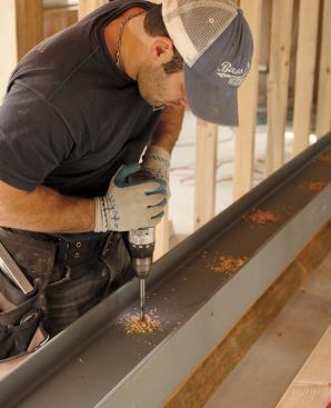 They flipped the beam over, and used the holes in the web to drill through both pieces of lumber.