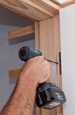 Three-inch-long finishing screws anchor the jamb to the framing.