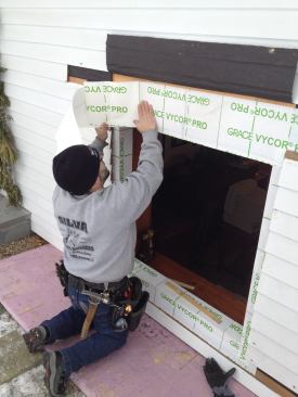 The flashing tape for the top of the window comes down flush with the edge of the opening.