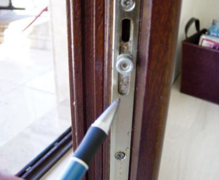 The problem wasn't the caulking or weatherstripping, but simply a small gap between the door handle and the faceplate, which allowed water to enter and run down through the threepoint locking mechanism. Note the rust spot on the hardware where the water came in.