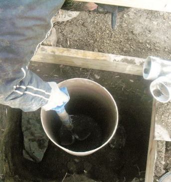 I press the bottom of the tube a couple of inches into the wet concrete, careful to keep it plumb, level, and at the proper elevation at the top.