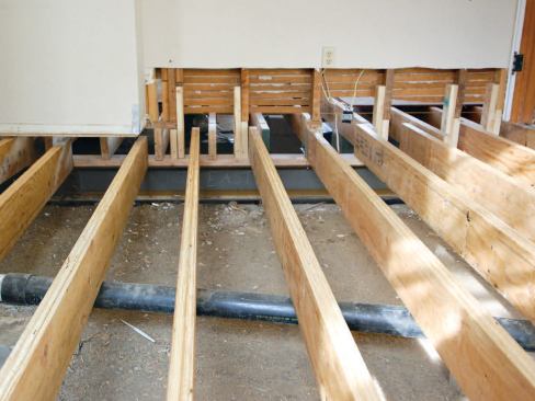Working a wall section at a time, the crew cut the studs off and extended them to the new girder under the bearing wall.