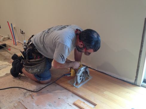 With the blade of his circular saw set at the thickness of the flooring, Manny saws through the boards to remove material quickly. At this point he is rough cutting all but one of the boards to length.