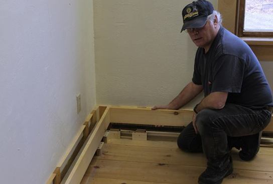 Stock 1x5 boards rest on the base blocks to create the cover face. Perpendicular lengths were glued and screwed together and the corner was installed as one piece.