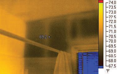 The relatively warm studs in this uninsulated exterior wall are conducting less heat to the outdoors than the framing cavities between them. Note the contrast with the partition wall at left and the insulated ceiling.