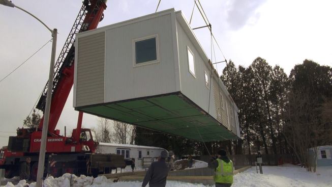 The crane eases the modular unit down into position on the stemwall foundation.