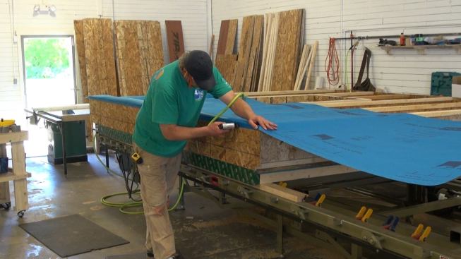 Stapling the Mento fabric to the underside edge of the wood I-joist cavity. This edge will be taped for air-tightness.