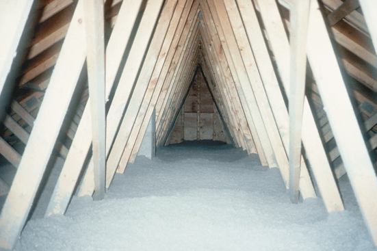 Cellulose insulation effectively fills all of the spaces around the bottom chords of roof trusses. Because cellulose is cheap, it can be piled on deep.