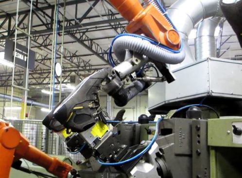 A second robot uses a Dremel-like tool to scuff the edges of the upper to create a better bonding surface for the polyurethane. This kind simple and repetitive task is the kind of thing robots are good at. 
Click here for video.