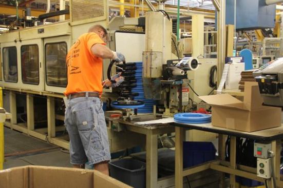 This fellow is assembling steel fish tapes. The steel arrives at this station pre-coiled—having been coiled by the machine to the left.