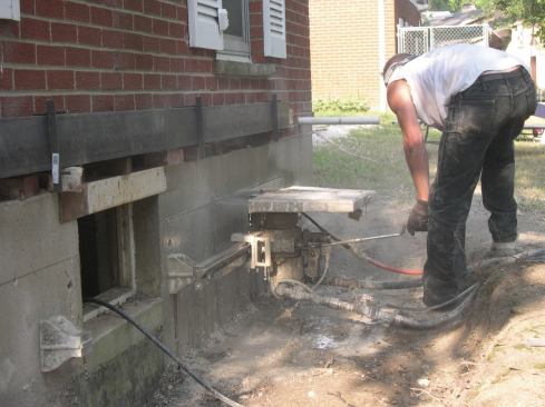 Cutting the beam pocket before excavating the walkout made setting the beam much easier. A steel rail bolted to the foundation guides the horizontal cut