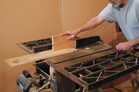 The heel of the push stick hooks on the work so that you are pushing parallel to the saw table instead of toward the blade.