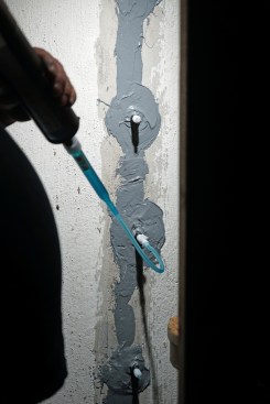 The paste acts as a dam material to hold the resin in the crack. To inject the resin, Toby starts at the bottom and works his way up, injecting enough into each port until it begins to ooze out the port above. 