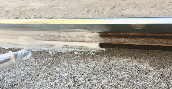 Caulk. Caulk the gap between the concrete and the plywood with your best, high-quality caulk. Do not fill the weep holes.