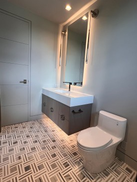 Here we see it behind the mirrors and under the floating vanities in the bathroom.