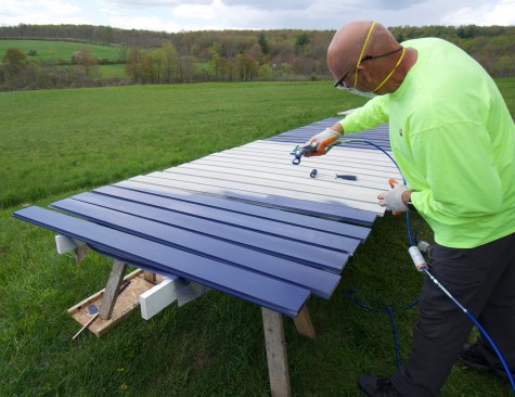 The author prefers to prefinish both siding and trim before installation. Here he uses a Graco 390PC airless sprayer.