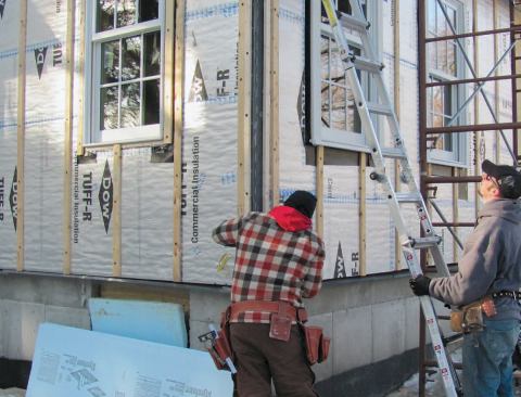 With the foam sheathing serving as a drainage plane, 1x3 vertical strapping creates a venting and drying space behind the siding. Additional strips around windows and doors provide separate backing for trim and siding.
