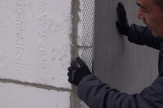 Remodeling contractor Jose Maldonado, owner of J’s Custom Contracting in Brooklyn, New York, points out the elements of a Sto exterior insulation finish system (EIFS) cladding for the masonry walls. The cladding system consists of a 4-inch layer of expanded polystyrene (EPS) insulation, with a galvanized steel reinforcing mesh, a cementitious base coat, and a colored cement stucco top coat.