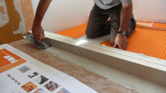 Boucher applies mortar to the previously installed sloped shower base (the installation of the shower base and drain is not shown here, but is covered in a different slideshow).