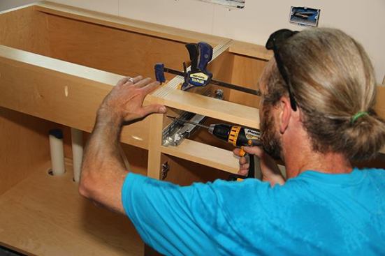 After setting two cabinets, Jeff clamps the pair up and screws them together.