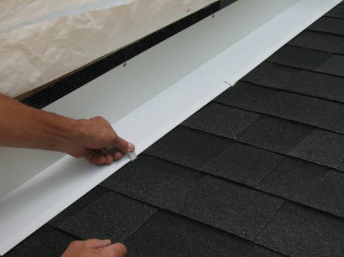 The final step is bending the clips over the edge of the continuous flashing. As with the under-flashing method, flashing tape between the continuous flashing and the shingles can provide added protection.