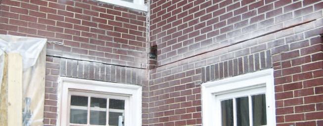 Working off the 6-foot-by-8-foot deck of the addition, the crew first kerfed the mortar joints to receive the steel angle.