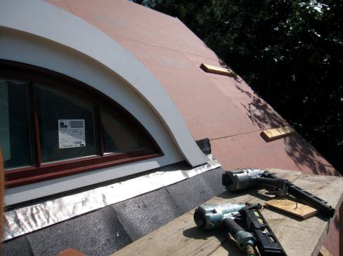 The fascia layers extended past the window trim with space left below for shingles. The final layer of fascia would be installed after the roof was sheathed.
