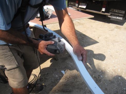 A belt sander was used to smooth the inside curve of the PVC window trim. This piece would be installed last, once the dormer roof had been sheathed.
