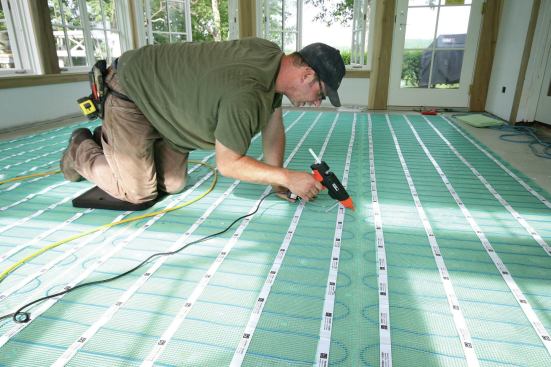 A glue gun was all that was needed to tack the mats in place so they didn't shift during the installation of the self-leveling compound.