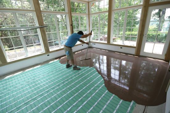 A float-like tool was used to level the self-leveling underlayment to the tops of the previously installed screws.