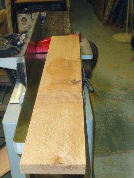 After several passes on the jointer, the rough areas have gotten smaller, but the board is not quite ready.