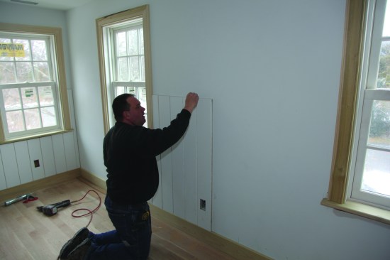 After making cutouts for the window and the outlet, the author dry-fit the piece and drew a pencil line on the wall along the perimeter.