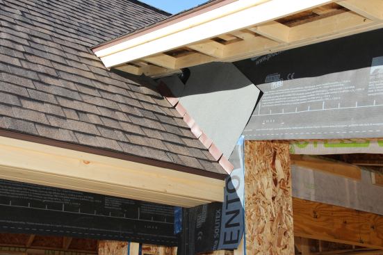 A view of the sunny side of the Kruse project, showing the completed eave framing and finish fascia, as well as housewrap and roof and wall flashing details.