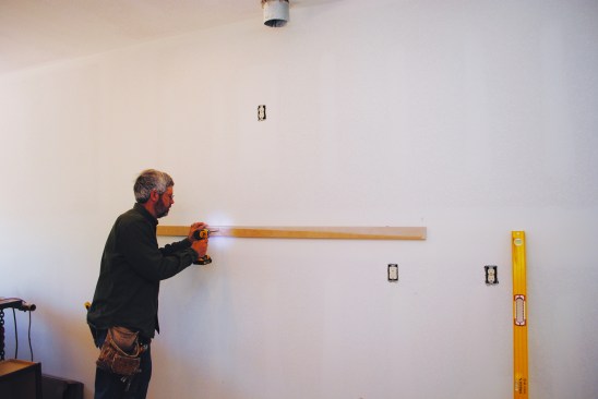 Then he screws a temporary cleat to the wall on the line.