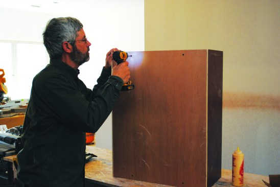 The cabinet backs screw to the cabinet bottoms through predrilled holes.