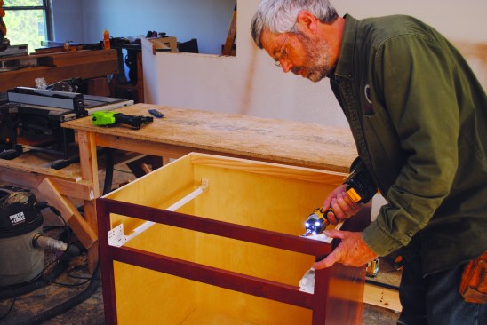 Base cabinets receive plastic corner brackets that help to keep the cabinets square while they are installed.