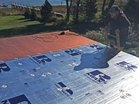On one roof area, a raised-perimeter trim around the roof called for additional build-up, so a 1-inch-thick underlayment (R-Max Thermasheath-3) was installed. For both the 1/2-inch and the 1-inch thicknesses, the underlayment was fastened to the deck with using common screw-down plate fasteners on nominal 2-foot centers.