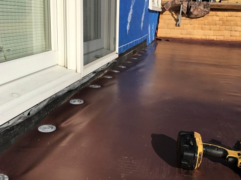 To terminate the membrane against a wall or parapet, the membrane is cut to the junction and fastened at the edge with the membrane stress plates.