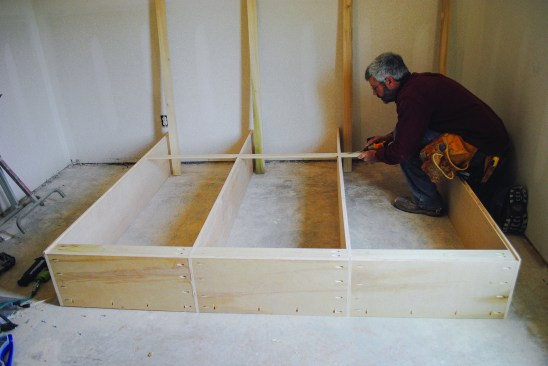 A second set of cleats act as spreaders and blocking to catch the bottom edge of the plywood back. To account for the plywood, the two inboard verticals were cut 3/8 inch narrower than the outboard ones and the outboard verticals received 3/8-inch-deep rabbets along the inside edges. The extra depth gives the plywood back plenty of room.