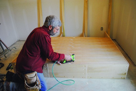 The back. Because the upper cabinet is more than 4 feet tall, the back consists of two pieces. The author glues and nails the 1/4-inch plywood back to the cleats and to the verticals.