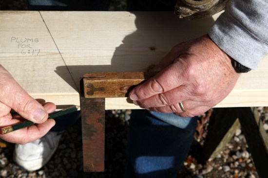 The cheek cuts for the top of the rafter are cut from both sides. To locate a plumb line on the opposite side, first square down the edge of the stock from the end of the plumb line.