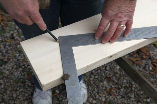 Flip the stock over, align the square with the line on the edge and draw the plumb line on the opposite side.