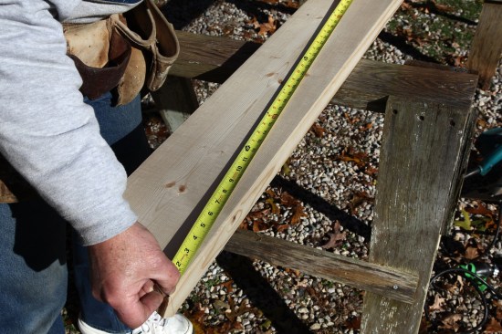 After taking the measurement as seen in the illustration, one crew member holds the end of the tape on the inside of the cheek cut at the top of the rafter.