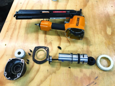 Lightly tap the cap with a rubber mallet to loosen it, if necessary. Continue to remove the parts of the nailer, and lay them out on the bench top in the order that you remove them.