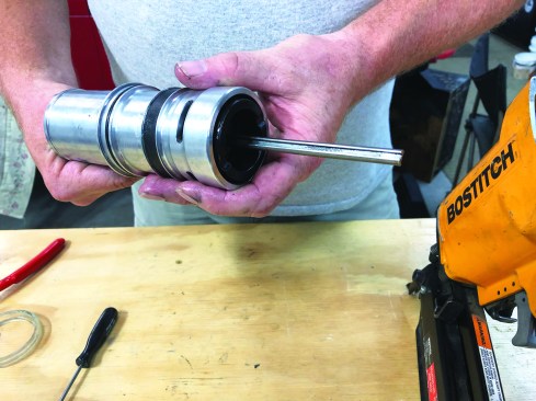 Next, slip the driver-piston assembly into the cylinder sleeve, pushing it all the way through with the shaft protruding from the bottom.