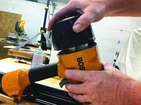 Press the cap onto the nailer frame in the proper alignment, pushing down hard on the cap to depress the compression spring.