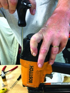 While holding the cap in place against the nailer frame, insert and start to thread all four screws into their holes. It’s important to tighten the screws evenly, so tighten them corner-to-corner, a few turns at a time.