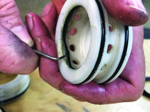 Remove the piston stop and compression spring from the piston head valve and wipe them both clean. Using a pick hook, remove the inside O-ring from the piston head valve.